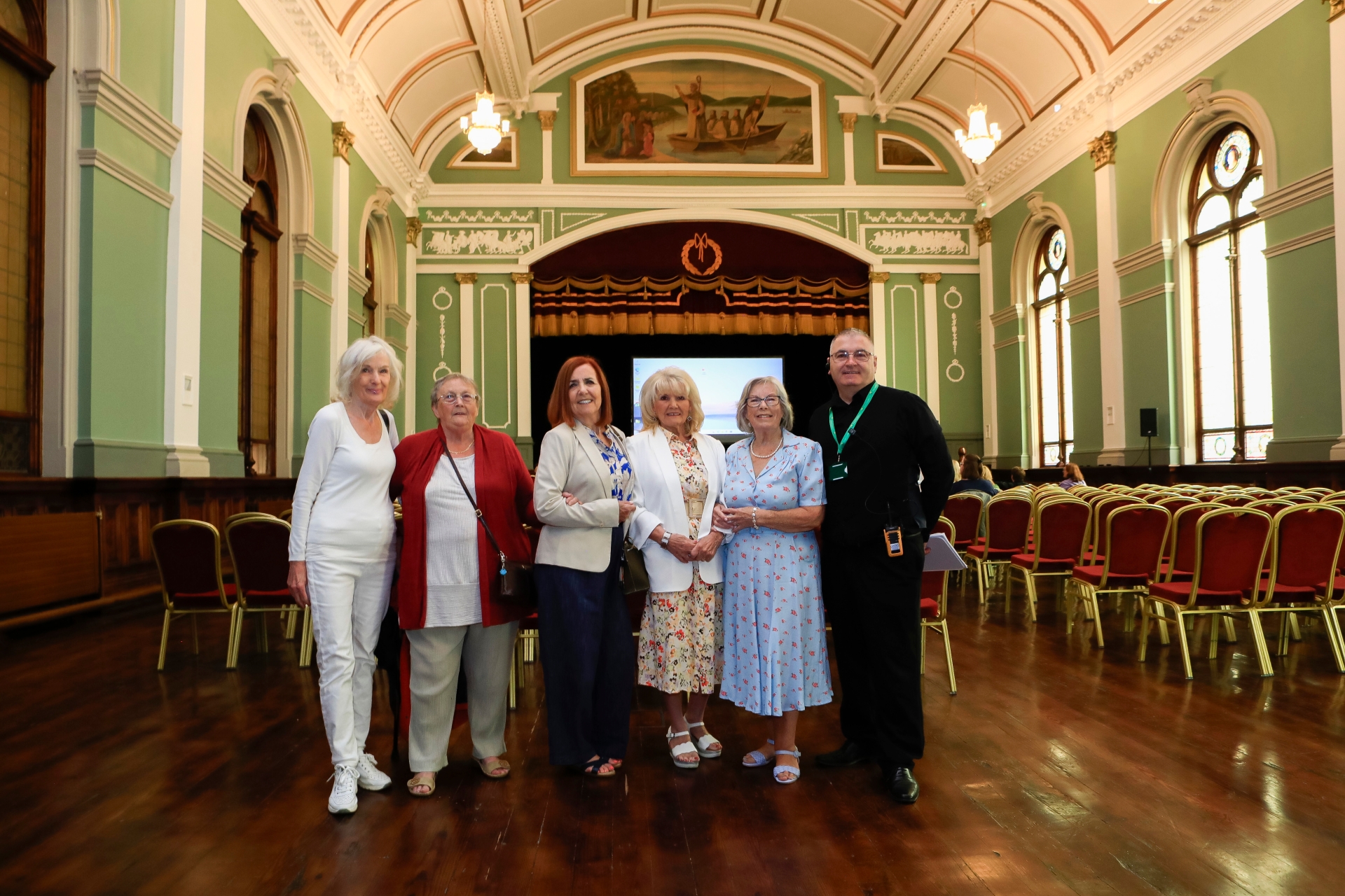 Factory Girls: Teresa McLaughlin, Rosemary Doherty, Sadie O'Kane, Mary White and Clare Moore with The People's Hall tour guide, Gerry Dorrity, in St Columb's Hall.
