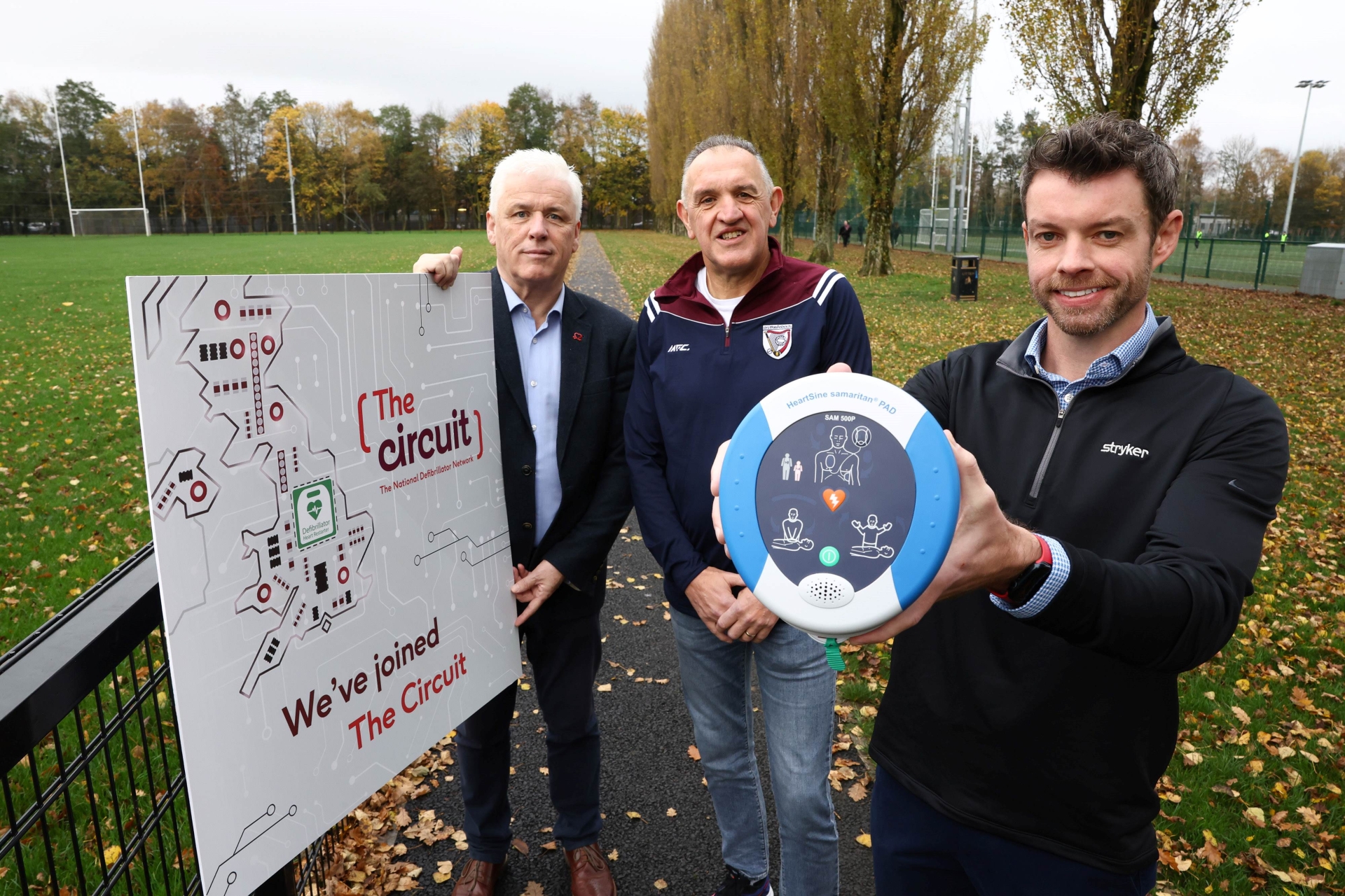 John Deery (centre) from Eglinton survived a cardiac arrest at this year’s Belfast Marathon thanks to a life-saving defibrillator and CPR performed by Peter O’Hare (right holding the defib)