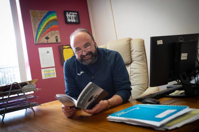 Derry poet Feargal Friel pictured at Hollybush Primary School this week with the first copy of his book 'The In-Between' (Photo: Jim McCafferty Photography)