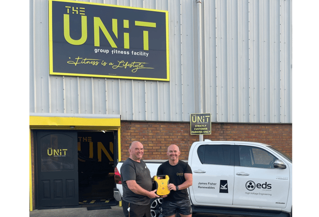Malcolm (left) pictured with gym owner, Gareth, and the new defibrillator donated to Unit Gym