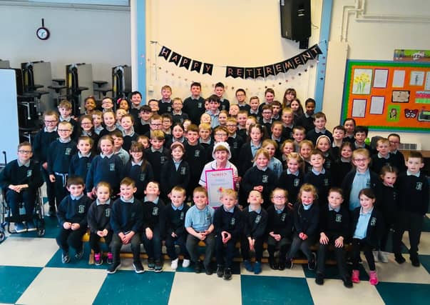 Noreen Mitchell, cook at St Patrick's PS, Moneymore pictured with pupils last week before she retired.