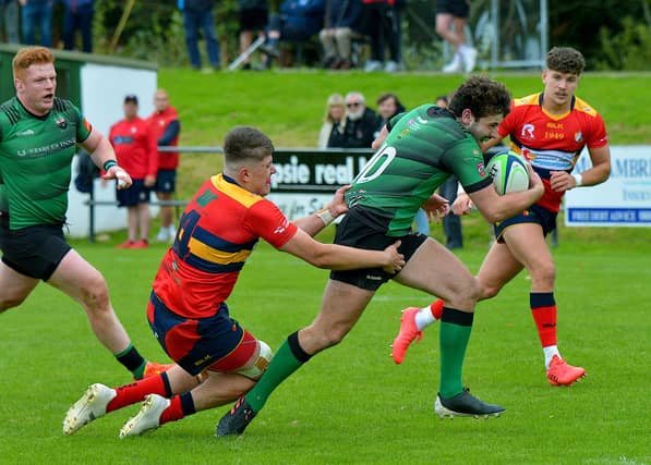 City of Derry’s Alex McDonnell, on his way to scoring a try, is hauled back by Ballyclare’s Luke McIlwrath. Photo: George Sweeney, nwpresspics