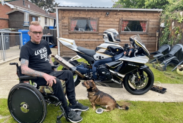 Sean pictured in front of the custom built bike that allows him to ride and his beloved dog, Buster