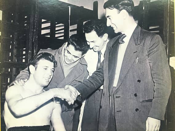 Mickey Diamond is congratulated in the dressing room after winning the Ulster Heavy Weight title in 1951. He is pictured with 'Spider Kelly' from Derry who was World Champion at that time.