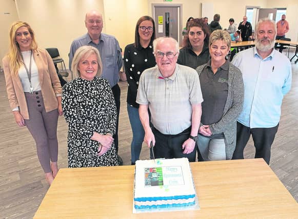 Colm Cusack cutting the cake to celebrate his retirement from Destined. Included are staff who organised the retirement lunch.