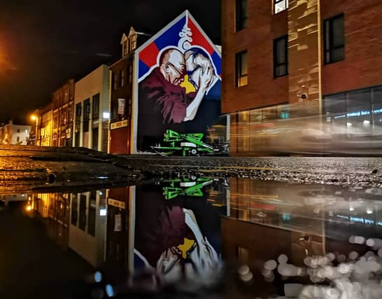 The mural of the Dalai Lama and Richard Moore is located at Great James Street.