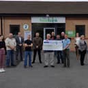 The singers hand over the money to the local food bank.