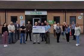 The singers hand over the money to the local food bank.
