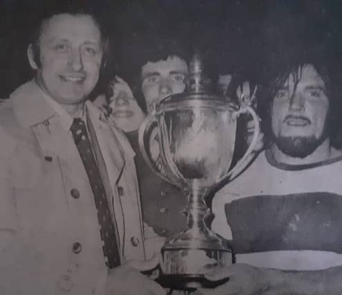 Tommy McKenna receives the John McLaughlin Cup from Derry Chairman Patsy Breen
