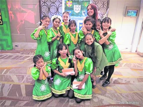 Derry woman Caoimhe Deeney pictured with the dancers who make their own costumes but have no Irish dancing shoes.