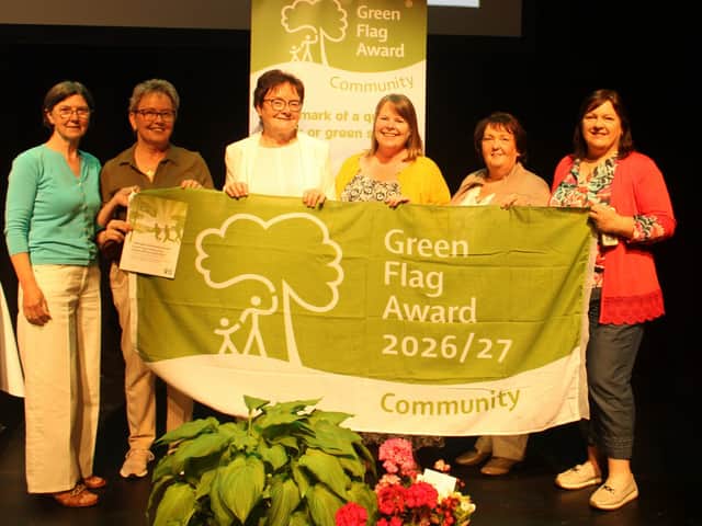 Some members of GDWG's Happy Gardeners group, delighted to accept GDWG's first-ever Green Flag Community Award, alongside their TCV tutor, Jenny