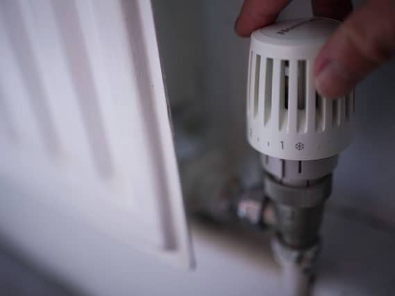 A person adjusts a radiator knob