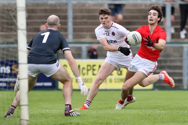 Magherafelt's Conall Higgins with Conor Coyle of Slaughtneil closing in during last week's Derry Senior Football Championship match at Owenbeg.