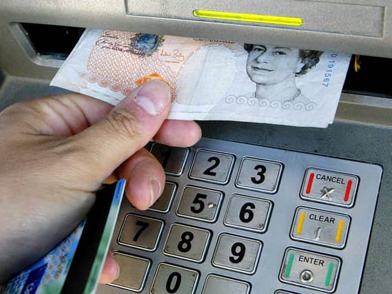 A person taking cash from an ATM