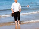 Fr Paddy O'Kane paddling in the water at Culdaff Beach. A new book is being written about the beloved late priest, with people being asked to share their memories of him.