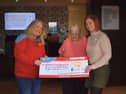 Pictured is Joanne McCallister, Chief Executive Officer at Children’s Heartbeat Trust, receiving a cheque from Julie Wallace, Lifestyle Care Home Manager at Milesian Manor, alongside resident Pat Kirkwood.