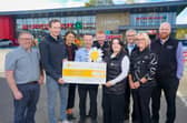 Connor Lynch, Lynch’s Director, presenting Cora McConnell from Cancer Fund for Children with a cheque for £14,000. Also pictured are Denise Ferguson, area manager at Lynch's, James Kelly from Lynch's Trench Road, Paul Hepburn, store manager at Lynch's Draperstown, Chris Curran, store manager at Lynch's Whitehouse, Peter Lynch, store manager at Lynch's Skeoge, Ciara Moore, store manager at Lynch's Caw and Steven McGreanery, store manager at Lynch's Greysteel.