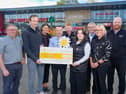Connor Lynch, Lynch’s Director, presenting Cora McConnell from Cancer Fund for Children with a cheque for £14,000. Also pictured are Denise Ferguson, area manager at Lynch's, James Kelly from Lynch's Trench Road, Paul Hepburn, store manager at Lynch's Draperstown, Chris Curran, store manager at Lynch's Whitehouse, Peter Lynch, store manager at Lynch's Skeoge, Ciara Moore, store manager at Lynch's Caw and Steven McGreanery, store manager at Lynch's Greysteel.