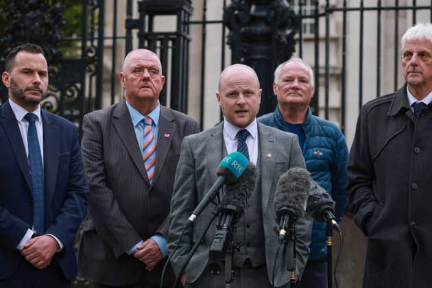 Loyalist spokesperson Jamie Bryson speaking to the media, with Timothy Gaston MLA (left), outside Belfast High Court