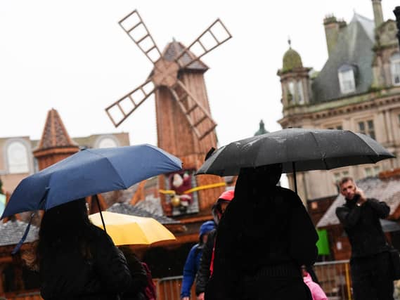 People in Birmingham hold umbrellas during wet and windy weather