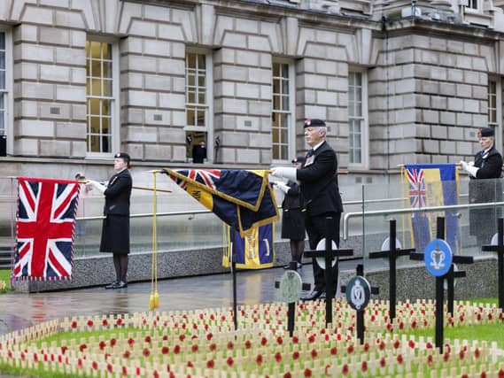 Standard bearers lower their flags in a mark of respect during the opening of the Field of Remembrance at Belfast City Hall