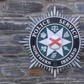 A PSNI badge on a wall outside a station