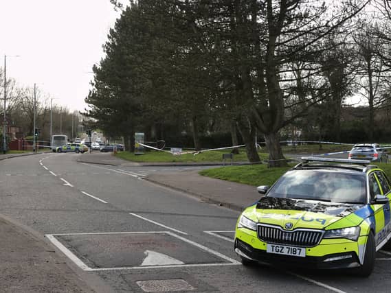 A PSNI police car parked across a road, blocking it