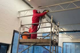Removing asbestos insulating board from a school sports hall