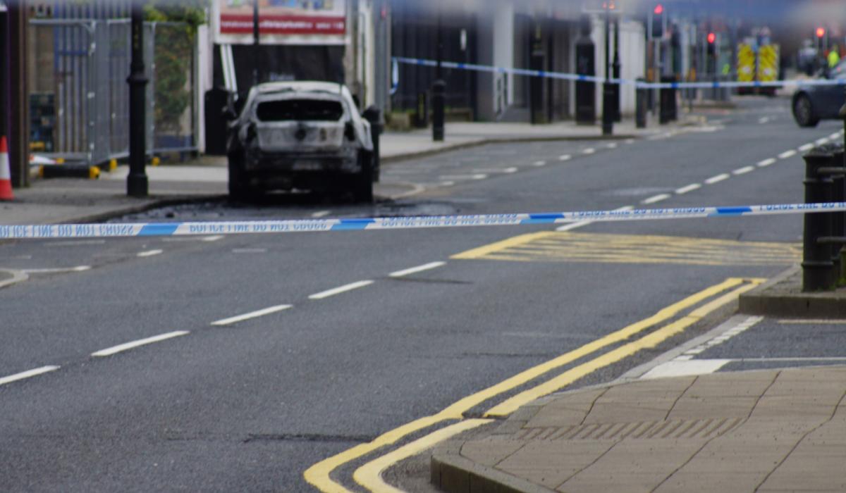 Burning car outside police station leads to road being closed off in