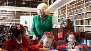Queen Camilla meets children and volunteers at historic library