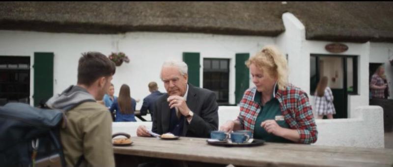 Pierce Brosnan sitting at a table of the pub