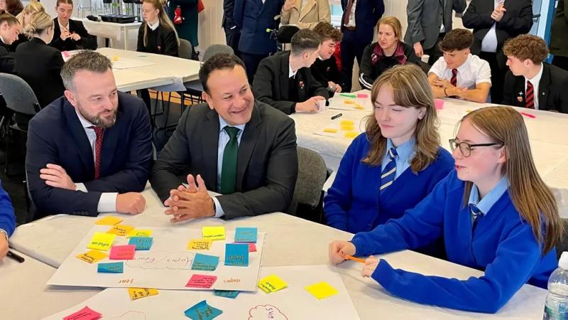SDLP leader Colum Eastwood and former Taoiseach Leo Varadkar with local pupils