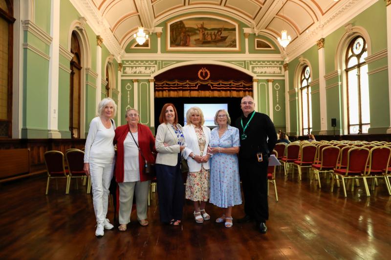 Factory Girls: Teresa McLaughlin, Rosemary Doherty, Sadie O'Kane, Mary White and Clare Moore with The People's Hall tour guide, Gerry Dorrity, in St Columb's Hall.
