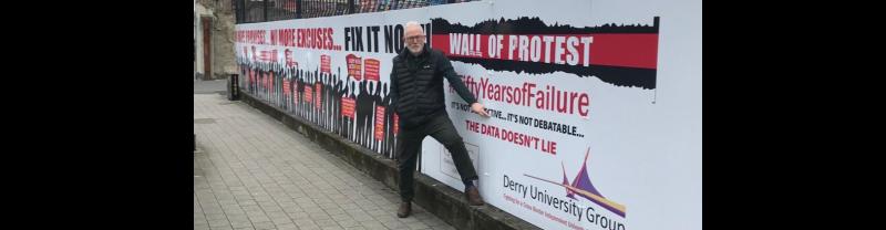 Conal McFeely with Derry University Group banner.