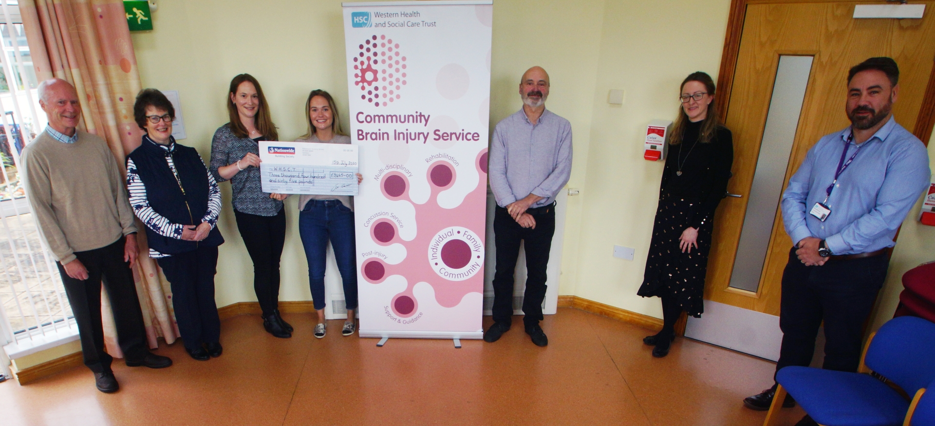 Pictured yesterday at the handing over of the cheque are, from left, Katie's parents, John and Wendy, Lizzie, Katie, Dr Paul Johnston, clinical psychologist, Carmel Greene, occupational therapist, and Dr Shane McCarney, consultant clinical lead at the Community Brain Injury Team in Derry 