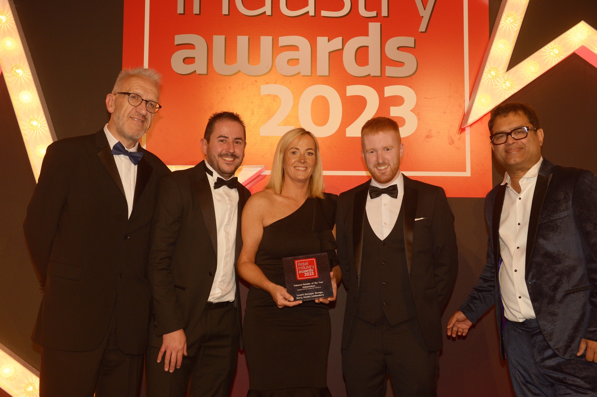 The team from Lynch’s EUROSPAR Skeoge are pictured with Independent Retail News editor, David Shrimpton (left) and Awards host Paul Sinah (right) to collect the award for Independent Tobacco Retailer of the Year at the Retail Industry Awards 2023.   