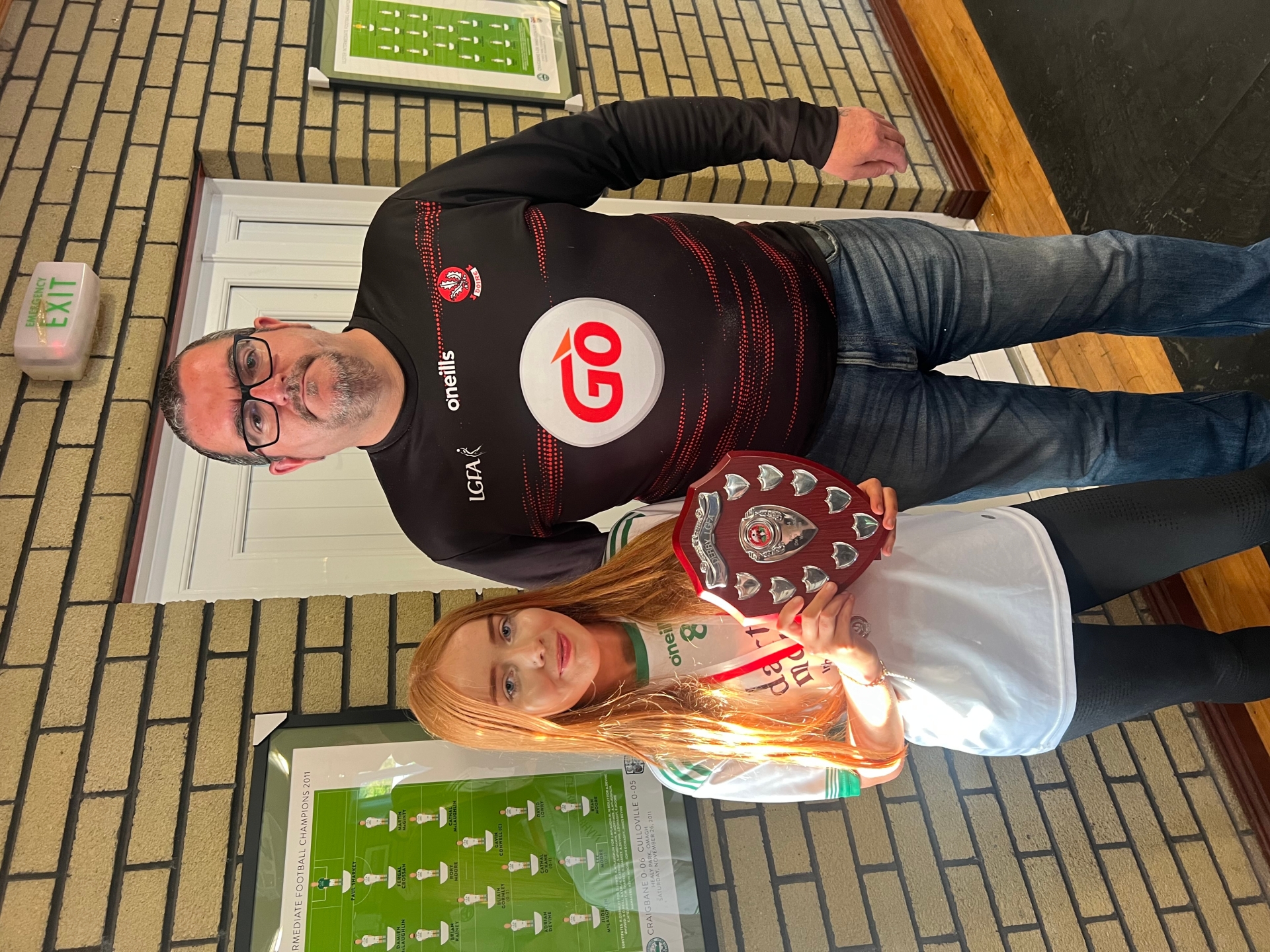 Eila Doughty is presented with the U14 League Winners' shield by Nigel Craig, representing Derry GAA.