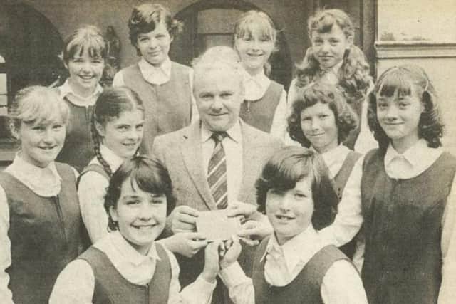 June 1981. Mr. Joseph Gamble, treasurer of Derry Lions Club, being presented with a cheque for £150 by representatives of the first year classes at Thornhill College, Artillery Street, Derry. The students organised a series of fund-raising efforts and their donation will benefit an Eye Camp in India.