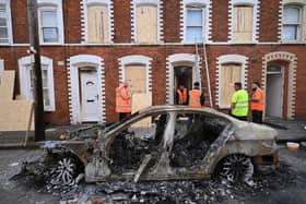 Residents begin to clean-up on Lendrick Street following a night of anti-immigrant riots on June 10, 2026 in Belfast. (Photo by Charles McQuillan/Getty Images)